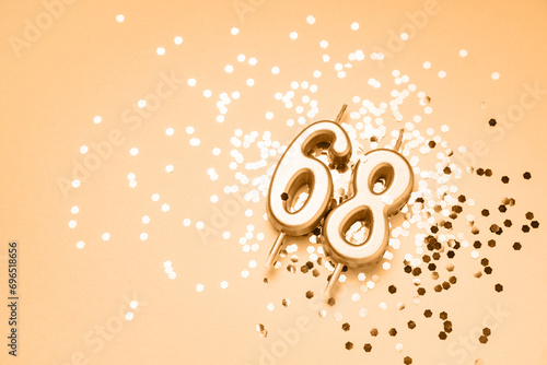 68 years celebration festive background made with golden candles in the form of number Sixty-eight lying on sparkles. Universal holiday banner with copy space.