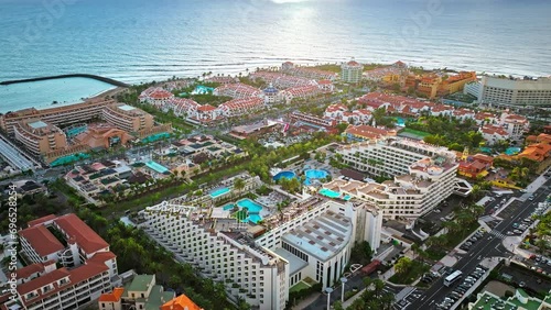 Aerial view of Playa de las Américas upscale resort and luxury hotels in Tenerife. View from above of a coastal resort district with sandy beaches and colourful villas in the Canary Islands, Spain. photo