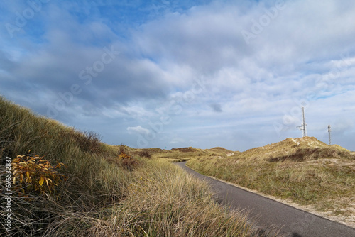 Krajobraz w Holandii Północnej, ścieżka rowerowa pośród wydm nad morzem.