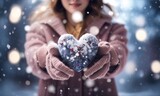 Winter snow christmas Valentine background greeting card - Closeup of woman with gloves holding a rod heart in her hands, defocused blurred bacground with snowflakes 
