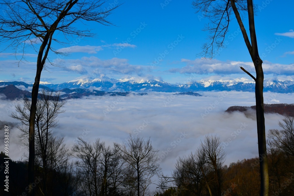 View of fog covered Gorenjska, Slovenia with snow covered mountains in the background