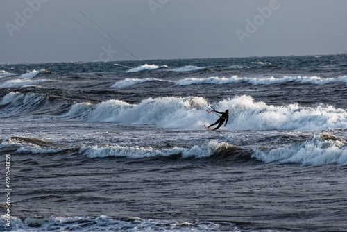 kite surfers ride the waves. Winter sport with high waves and many dangers. Wind and wave speed. Men and women do extreme sports People water sport lessons and beach swimming activity. 