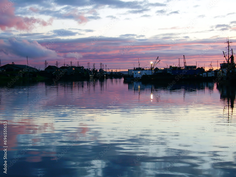 Silhouettes of Industrial fishing vessels on shore. After sunset. Dry docking