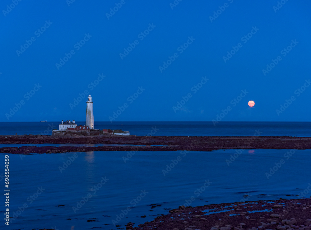 Naklejka premium St Marys Island and lighthouse with moon and copy sace.