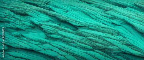Blue and green textured abstract background with copy space for design. Wide panoramic banner showcasing beautiful teal tones on a rough rock surface.
