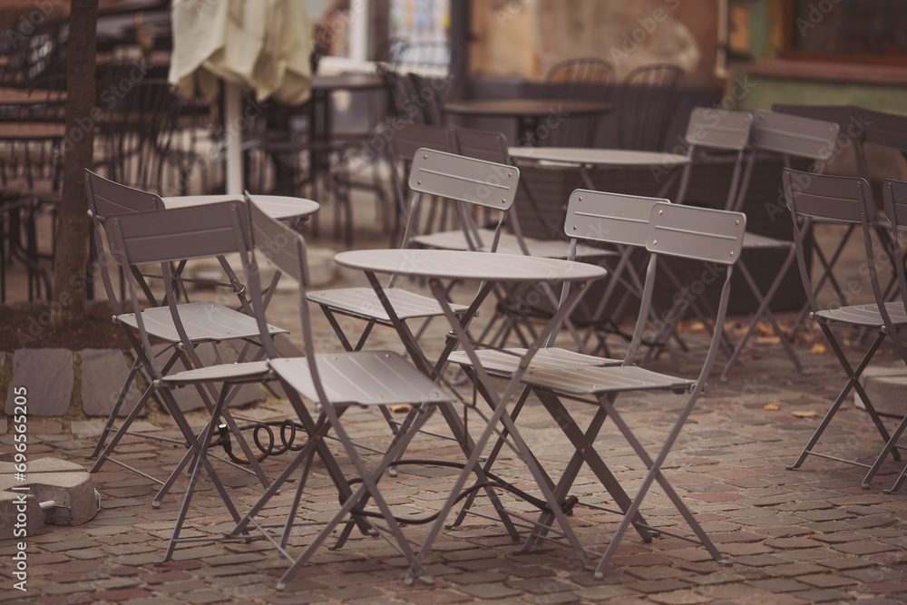 Coffeehouse cafe restaurant terrace. Wooden chairs and tables. Outdoor terrace concept. Shallow focus. Copy space. Old fashioned empty cafe terrace with vintage chairs and tables. Loft style cafe. Coffeehouse cafe restaurant terrace. Wooden chairs and tables. Outdoor terrace concept. Shallow focus. Copy space. Old fashioned empty cafe terrace with vintage chairs and tables. Loft style cafe.