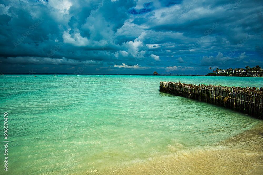 pier in the ocean with turquoise water and white sand