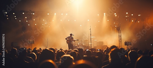 Blurred bokeh lights at music festival with live band and lively crowd dancing and singing along