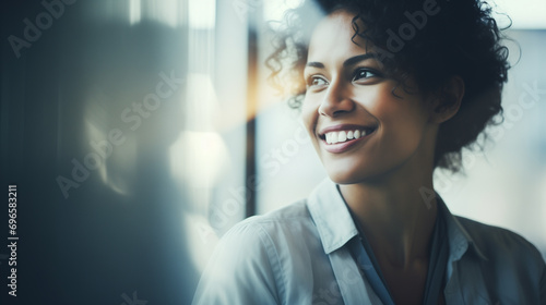 Bella donna con capelli ricci in un moderno ufficio con abito elegante e un bel sorriso