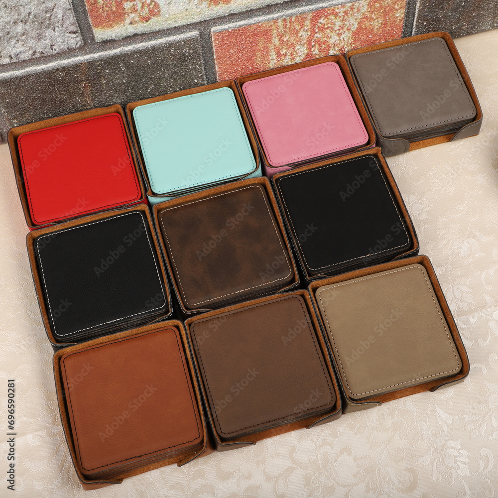 Fototapeta premium Leather table mats in different colors. Concept shot, top view. Custom background view of leather table coaster. Stitched and leather table coaster