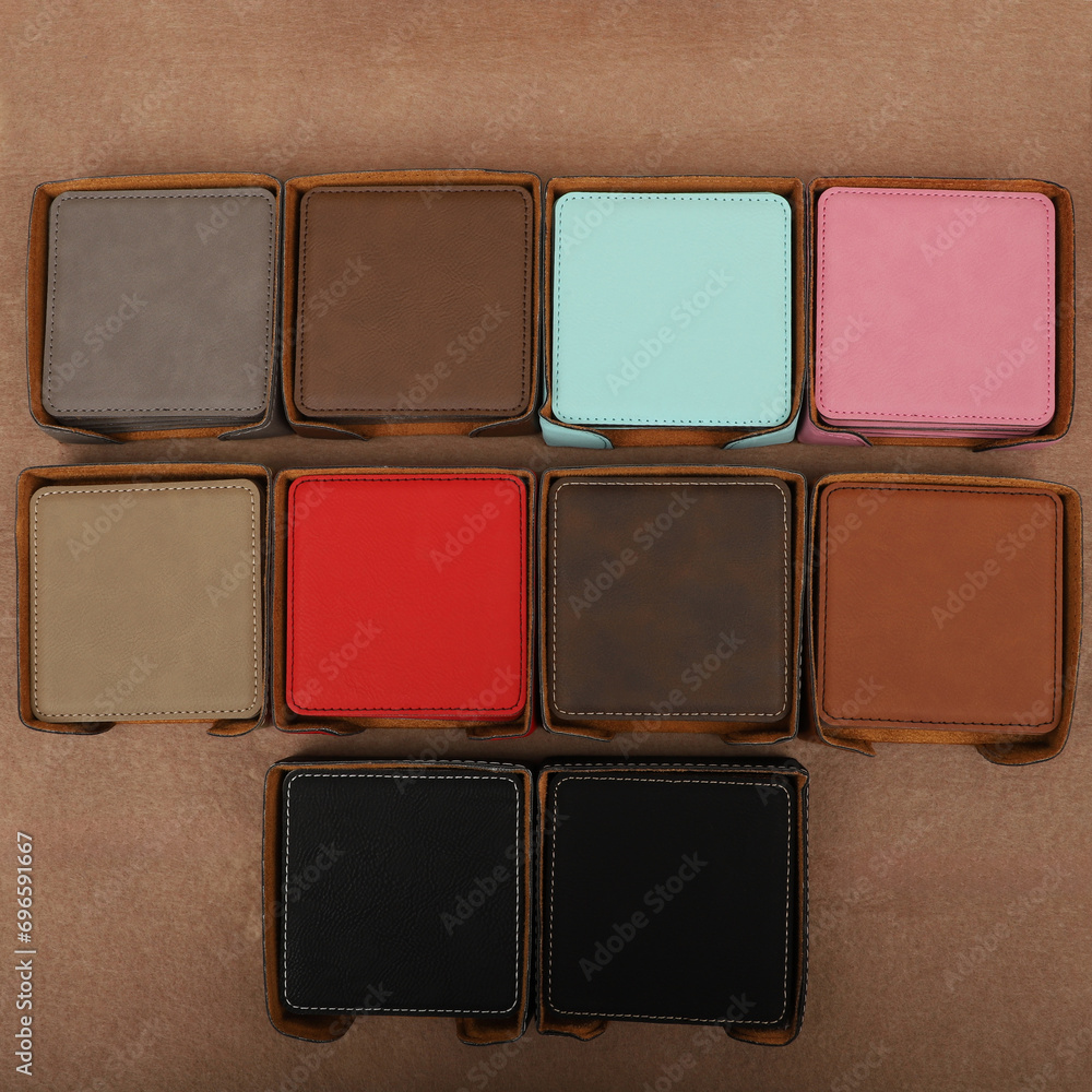 Fototapeta premium Leather table mats in different colors. Concept shot, top view. Custom background view of leather table coaster. Stitched and leather table coaster