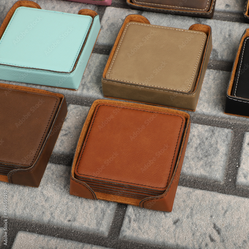 Fototapeta premium Leather table mats in different colors. Concept shot, top view. Custom background view of leather table coaster. Stitched and leather table coaster