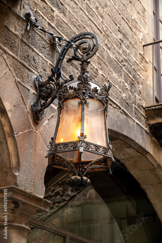 Historic wrought iron lantern with glass housing on an architecturally charming building