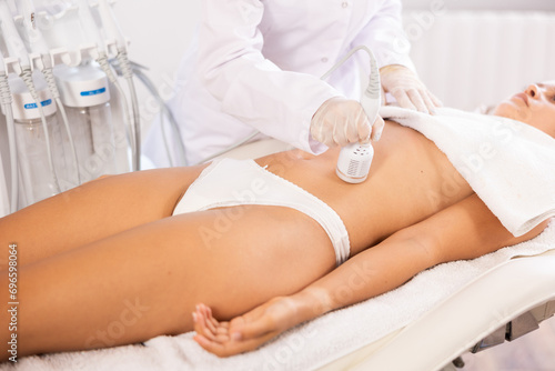 Belly massage with ice hummer attachement of beauty machine to female patient