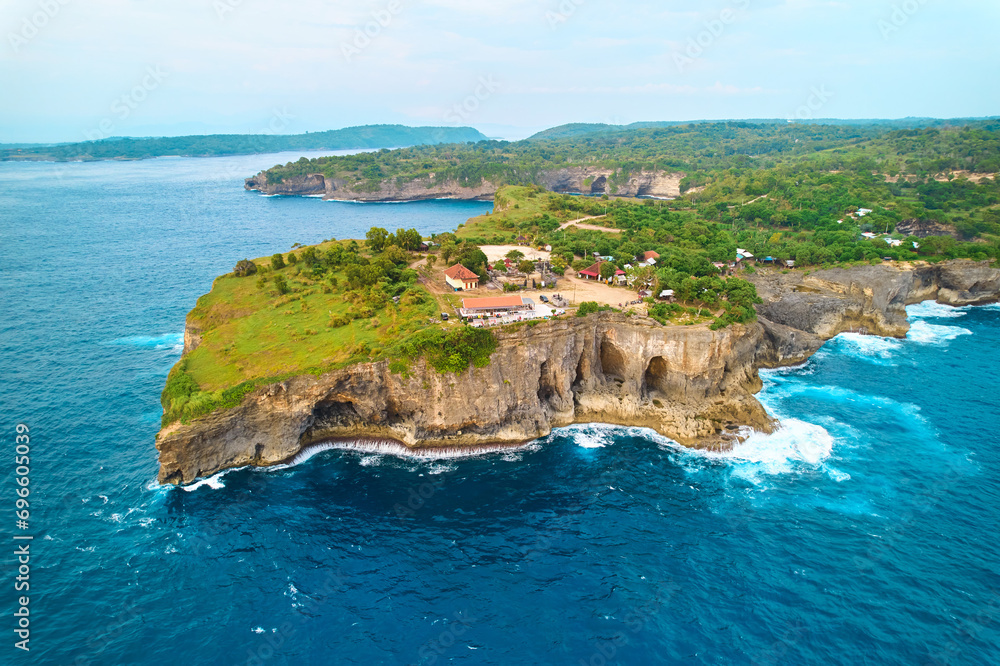 Cinematic aerial landscape shots of the beautiful island of Nusa Penida. Huge cliffs by the shoreline and hidden dream beaches with clear water.
