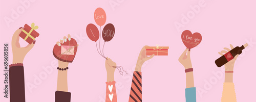 Female hands with balloons, gifts, greeting card and bottle of wine on pink background. Valentines Day celebration