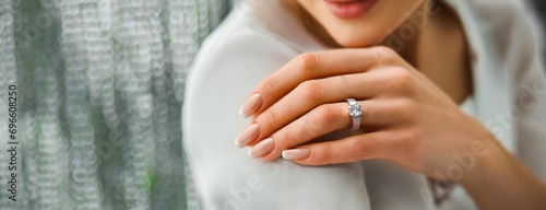 Woman Flaunting Her Elegant Diamond Engagement Ring. Close-up of a woman's hand as she shows off a sparkling diamond ring, symbolizing engagement photo