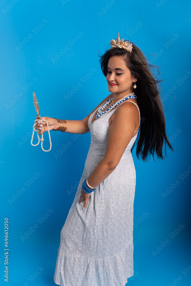 Portrait of beautiful black-haired woman wearing white outfit, holding a mirror. Portrait of beautiful black-haired woman wearing white outfit, holding a mirror.