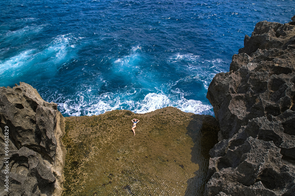 A cliff broken by an ocean wave. The cliff is washed by powerful waves of the ocean. A popular tourist destination Angel's Billabong on the island of Nusa Penida in Indonesia.