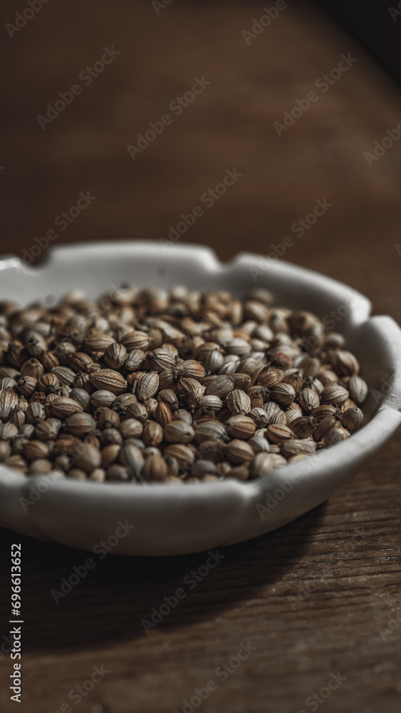 Coriander seeds in a bowl on wooden background. Close up. Coriander seeds in a bowl on wooden background. Close up.
