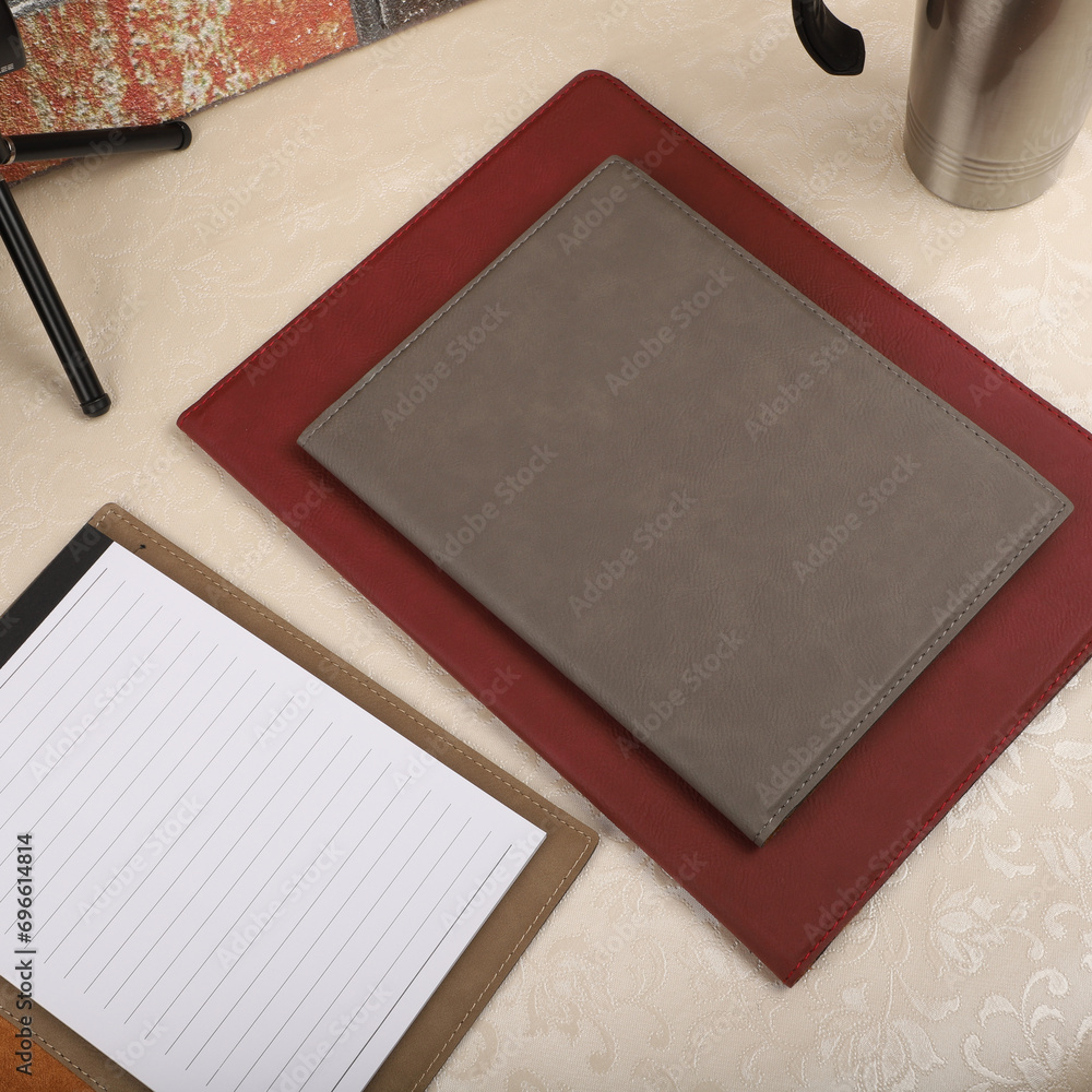 Fototapeta premium Leather portfolio. Concept shot, top view, portfolio in different colors and leather pen. Custom background flap portfolio view. Portfolio and accessories.