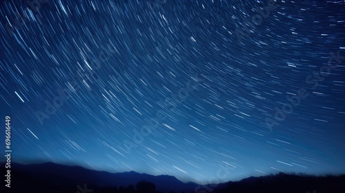 Star trails circling in the night sky above silhouetted mountains