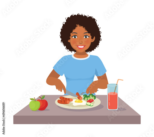 Young African woman eating sausage eggs and vegetables for breakfast