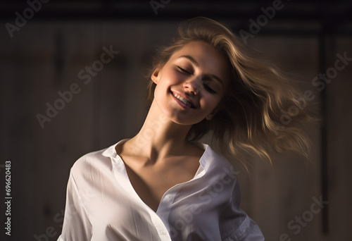 Joyful young blond woman having fun, dancing with happy smiling face and relaxed emotion