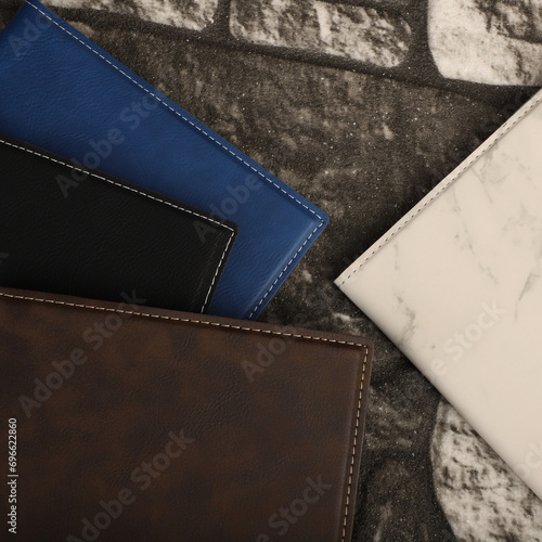 Leather portfolio. Concept shot, top view, portfolio in different colors and leather pen. Custom background flap portfolio view. Portfolio and accessories.