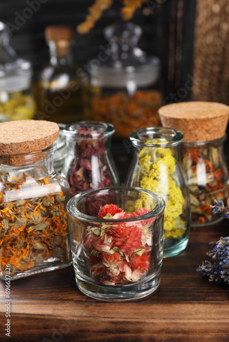 Many different herbs and flowers on wooden table