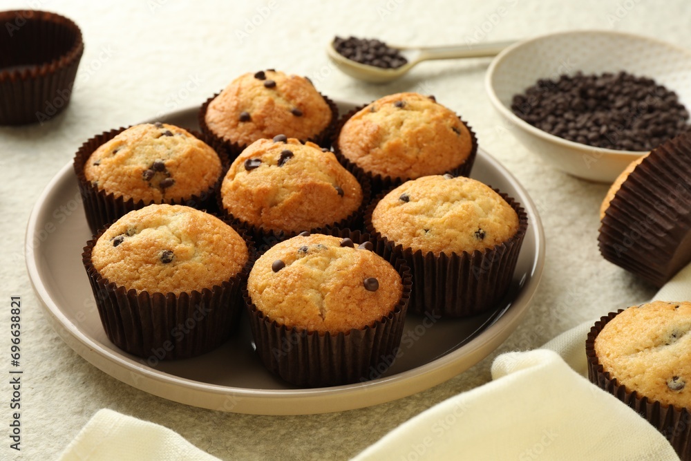 Delicious sweet muffins with chocolate chips on light textured table