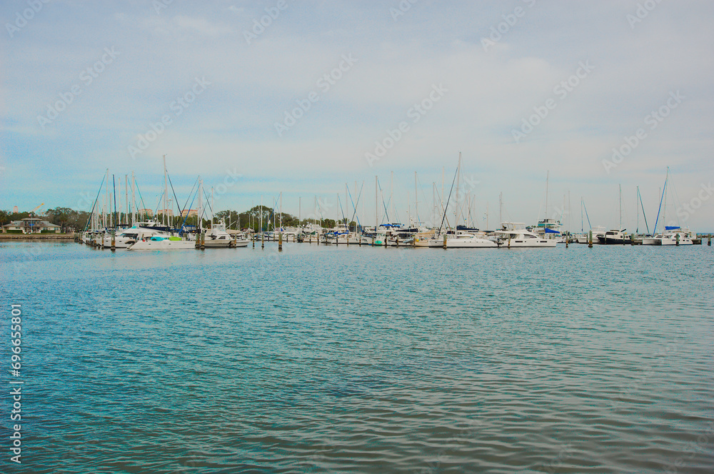 St. Petersburg, Florida Vinoy Basin View from South with blue water and sky.  Variety of boats wth masts on a partly cloudy day.
