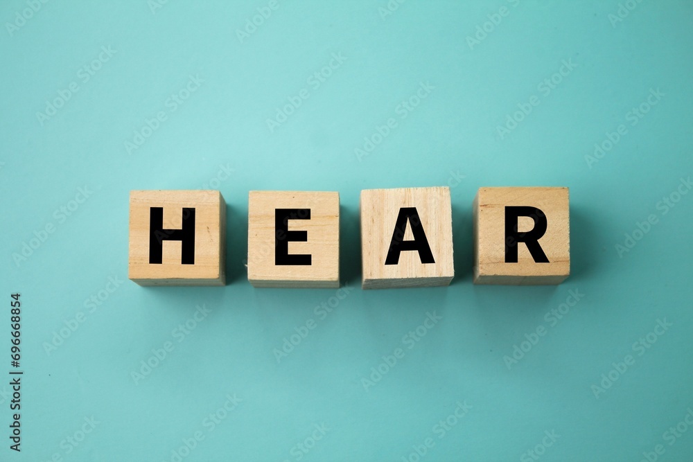 wooden cube with the word hear. the concept of hearing or being heard wooden cube with the word hear. the concept of hearing or being heard