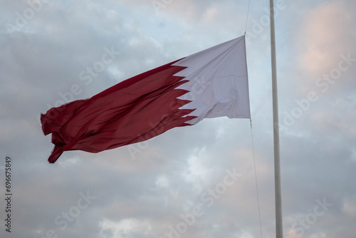 The Qatari flag hangs on the iron pole and flies in the wind during the Qatari National Day celebrations in Darb Al Saai, Qatar photo