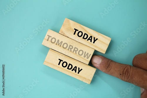 wooden arrangement with the word TOMORROW rejected. the concept of today and tomorrow with today's puzzle closes tomorrow. today's concept photo
