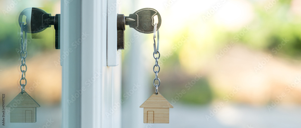 Landlord key for unlocking house is plugged into the door. Second hand house for rent and sale. keychain is blowing in the wind. mortgage for new home, buy, sell, renovate, investment, owner, estate - obrazy, fototapety, plakaty 