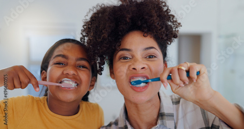 Portrait, bathroom and mother brushing teeth with child for oral health and wellness at home. Bonding, hygiene and young mom and girl kid with morning dental care routine together at house in Mexico. photo
