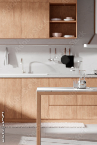 A bright beige-toned kitchen interior with sunlight coming through the window.