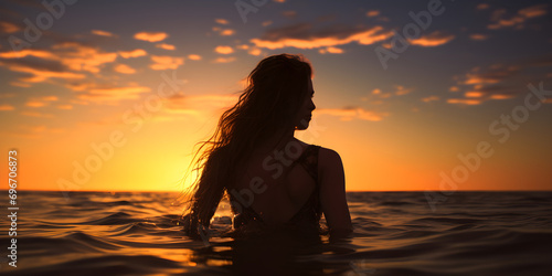 Woman s figure on beach at sunset with empty space, Young woman  silhouette against a sunset over the sea © Dear