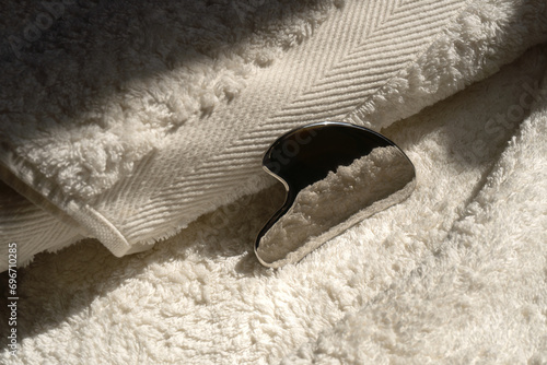 Guasha scraper lies on a towel