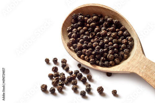 Black peppercorns on a white background. Wooden spoon with black peppercorns. Fragrant spices close-up.