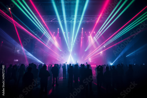 Laser beams are colorfully produced at a concert. The audience gets excited and cheers. Light for events and stages.