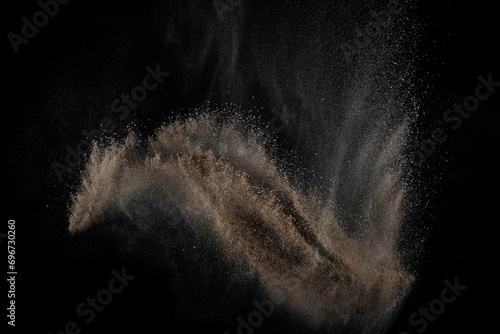 Soil explosion on black background. Abstract texture. Cloud of brown ground. Sand explode. 
