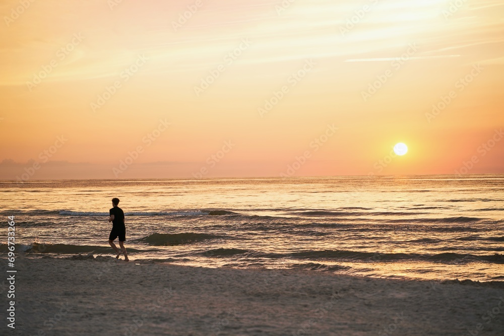 Endless Stride. Young Man's Sunset Run Along the Ocean Beach. Running on the sea beach.