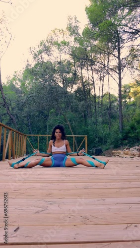Sportswoman doing flexibility exercises in the forest photo