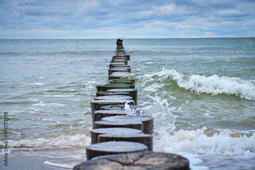 Groynes jut out into the Baltic Sea. Wooden trunks to protect the coast. Landscape