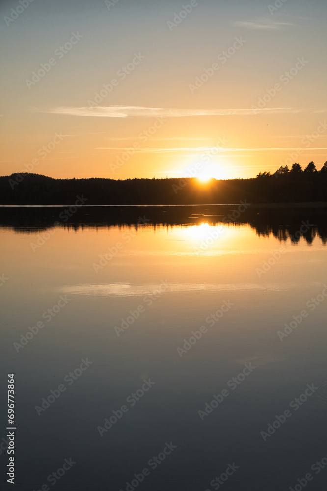 Sunset with reflection on a Swedish lake in Smalland. Romantic evening mood.