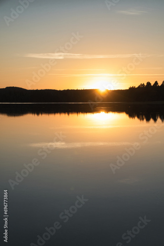 Sunset with reflection on a Swedish lake in Smalland. Romantic evening mood. © Martin