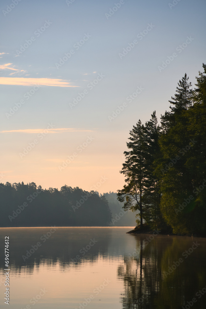 Fototapeta premium on a lake in Sweden in Smalland. Rock in foreground, blue water, sunny sky,
