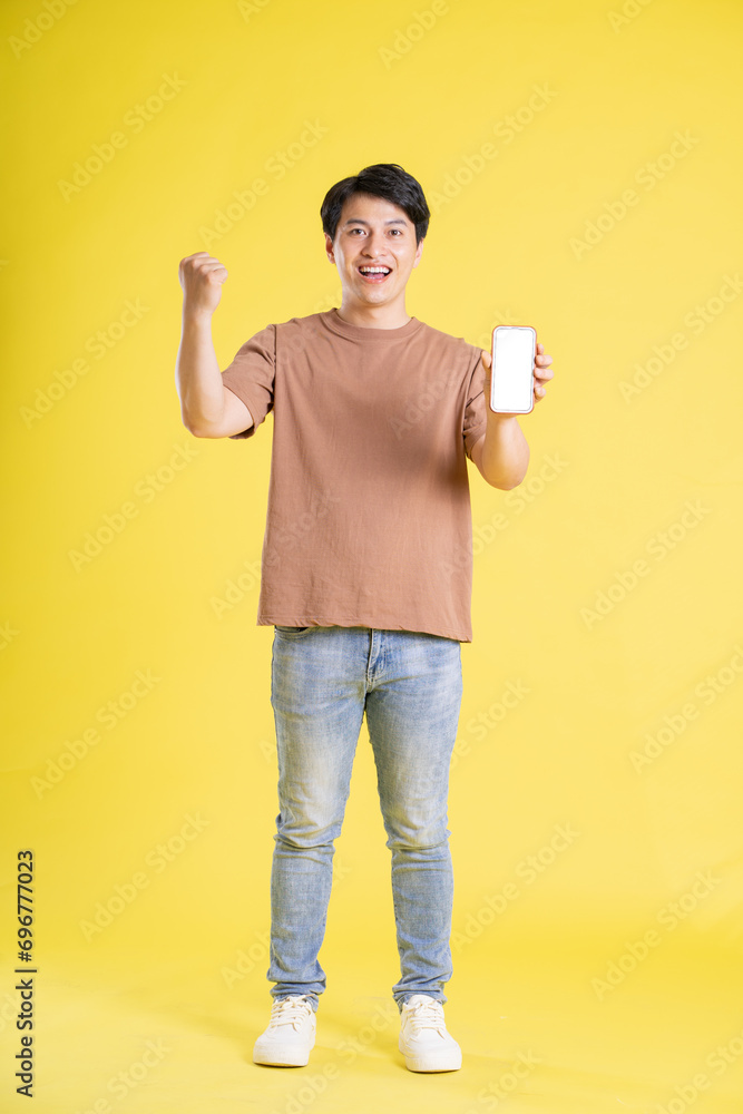 Portrait of asian man posing on yellow background Portrait of asian man posing on yellow background